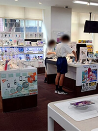 写真：開店前に展示スマホデモ機を整頓